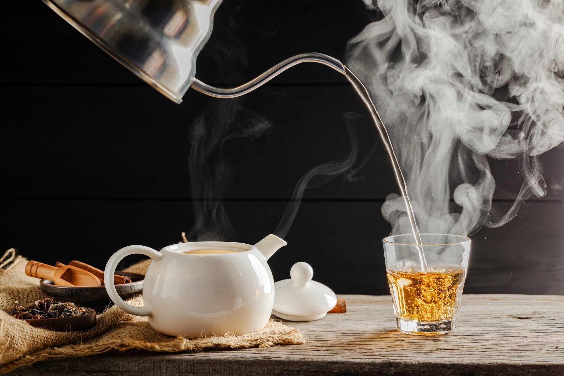 Hot tea poured into glasses with steam in morning sunlight
